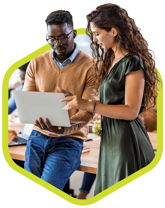 Young male executive wearing glasses shows a female coworker his computer.